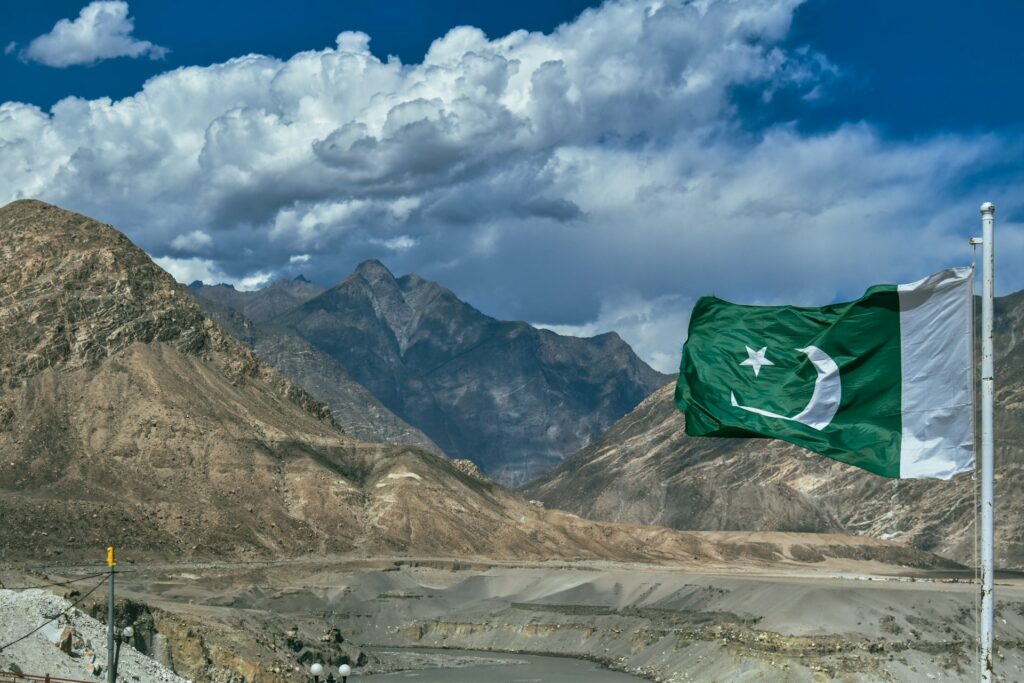 Flag of Pakistan waves in front of a mountain dessert backdrop
