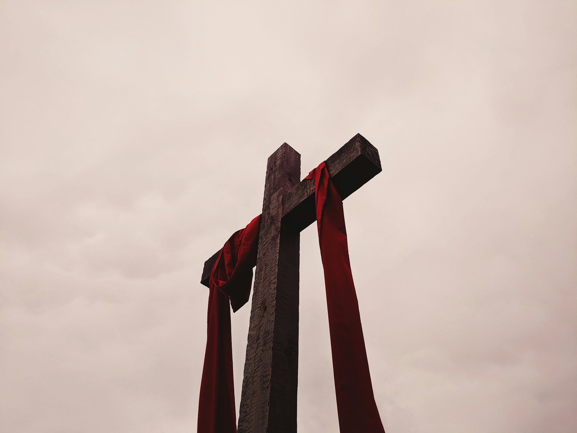 Wooden cross is draped with a red cloth